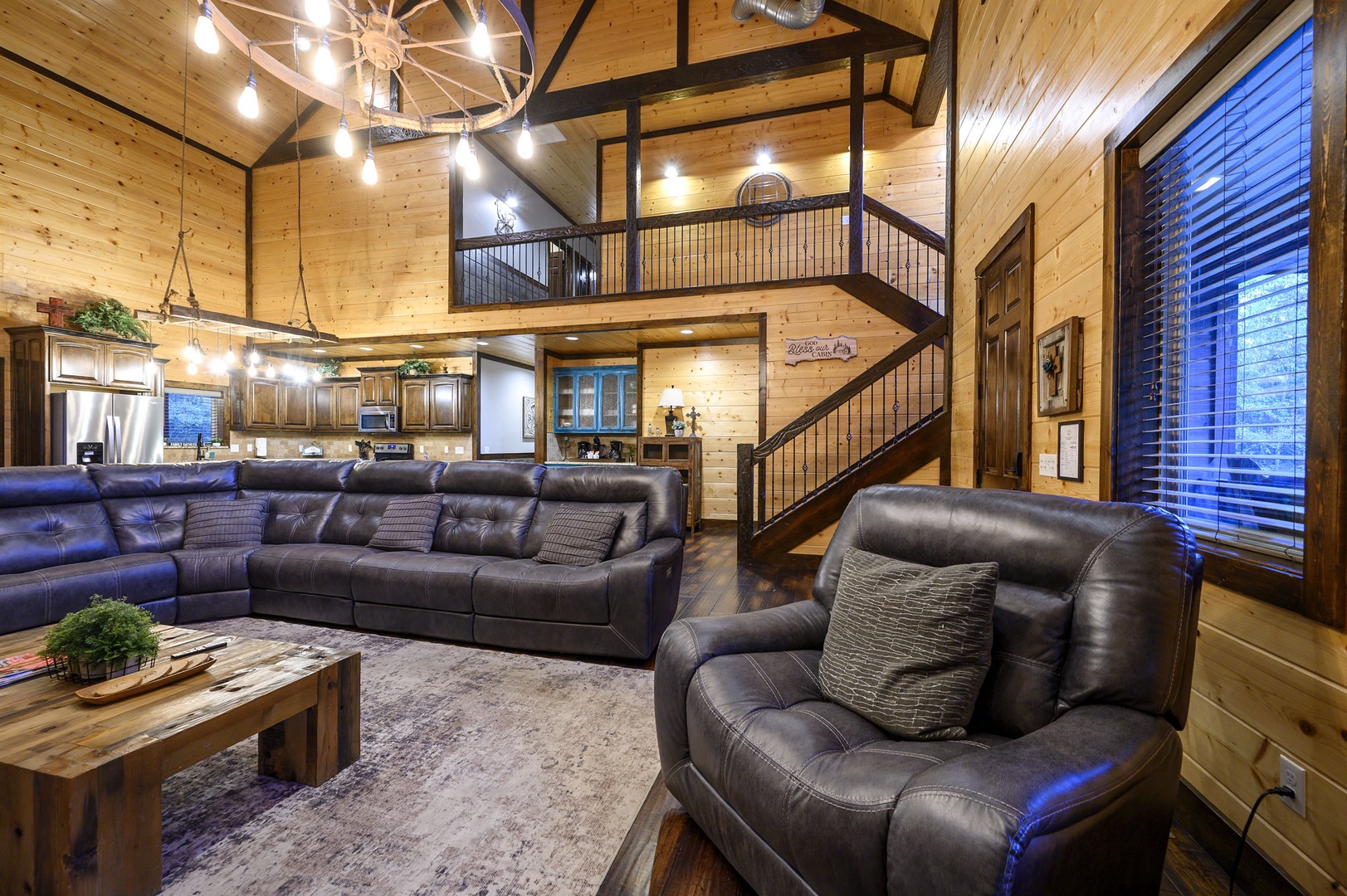 Sink into plush leather seating beneath soaring ceilings and warm wood beams, where your spacious living area opens to a stunning loft above and a fully equipped kitchen awaits.