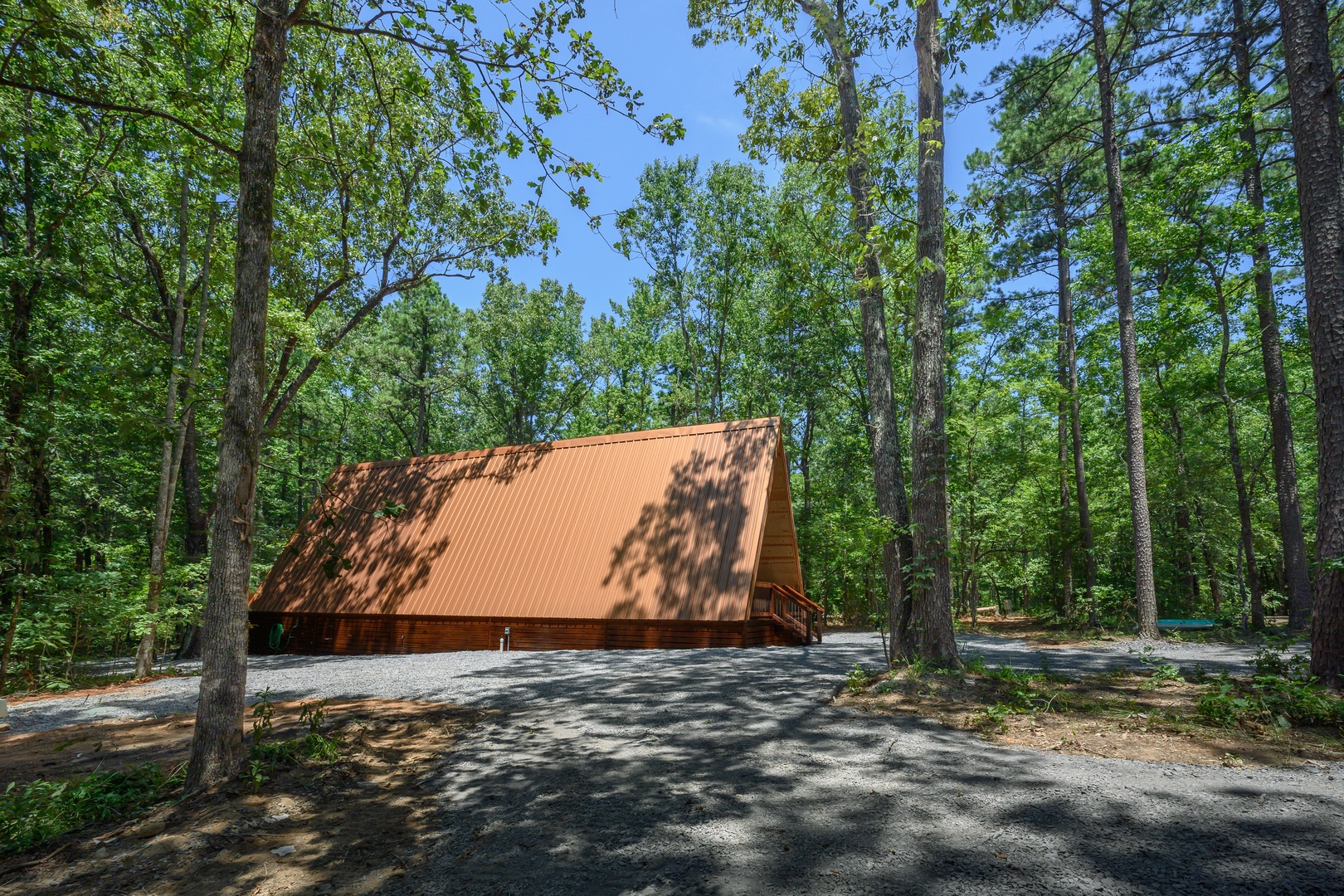 A charming A-frame cabin nestled in a peaceful forest setting, surrounded by towering trees and natural beauty—a secluded retreat where the outdoors becomes part of the experience.