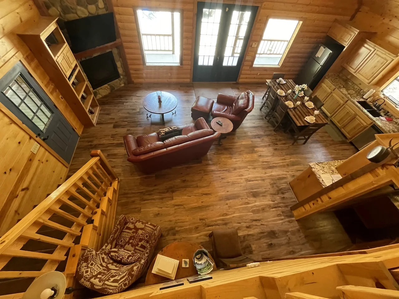 Relax in your spacious open-plan living area, featuring rich leather seating, warm wood throughout, and skylights that bathe the entire space in natural light.