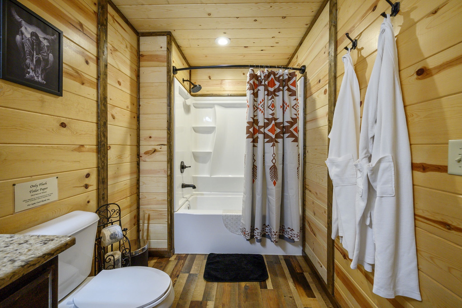 Step into your private bathroom with rustic wood paneling and a cozy cabin feel. Fresh towels and robes await, making it easy to relax and unwind after a day of adventure.