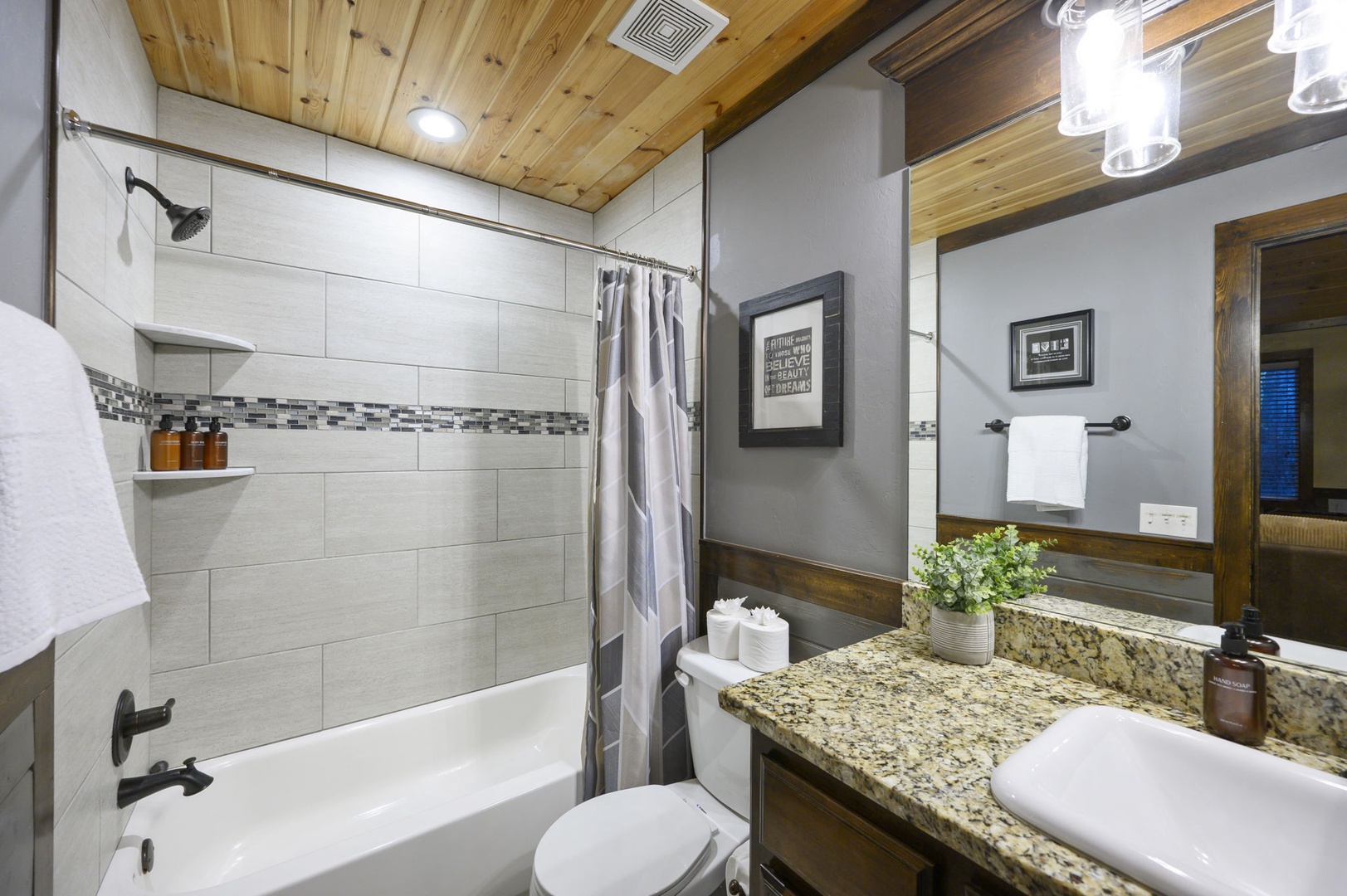 Step into this beautifully updated bathroom with warm wood accents, modern fixtures, and a soothing spa-like vibe. Fresh towels and thoughtful amenities await your arrival.