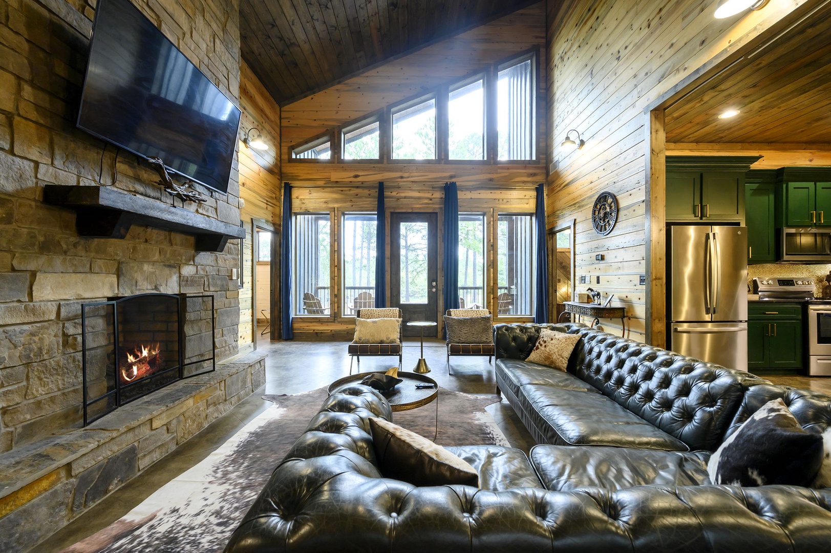 Sink into plush leather seating while the fireplace crackles beside you. Vaulted ceilings and walls of windows invite natural light to fill your space, connecting you with the wooded surroundings.