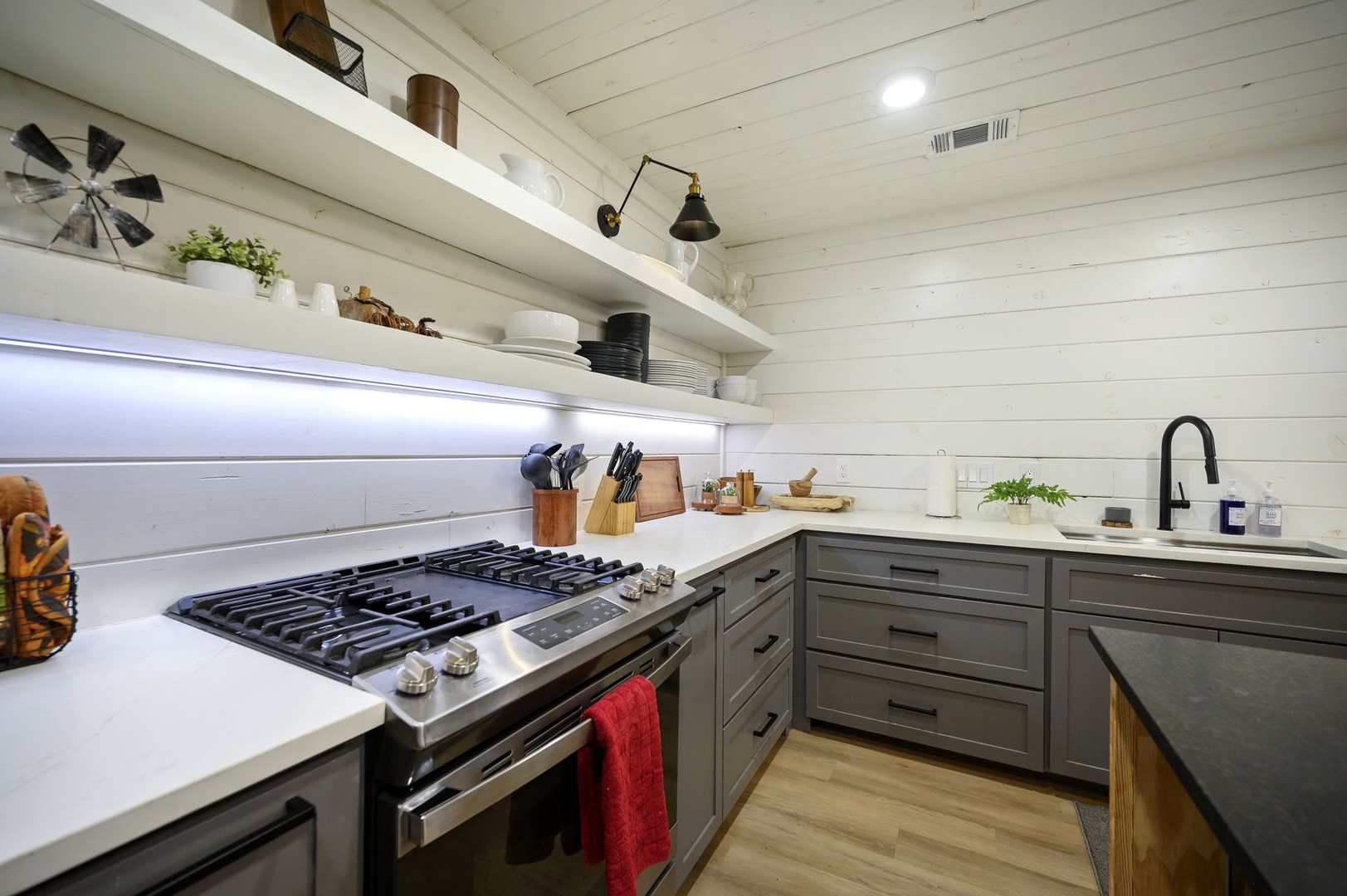 Your fully equipped kitchen features sleek countertops, modern appliances, and open shelving where you can create memorable meals together.