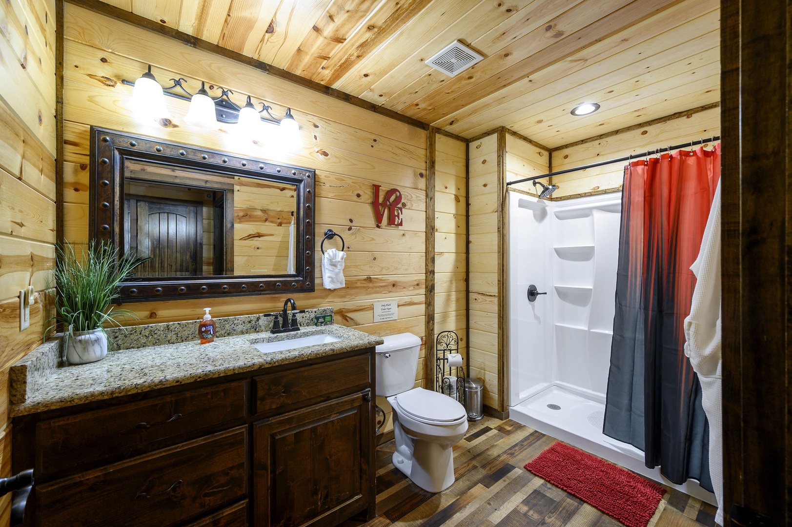 Step into your private bathroom where rustic charm meets modern comfort. Warm wood surrounds you from floor to ceiling, while a spacious walk-in shower awaits your morning ritual.