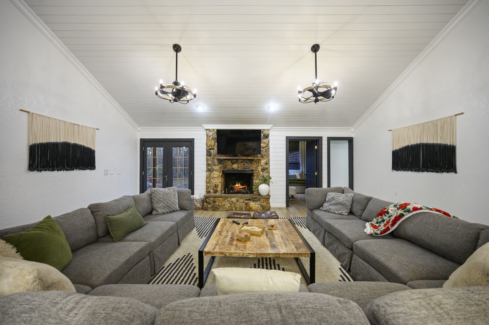 Sink into plush sectional seating while the stone fireplace crackles warmly, creating your perfect gathering space for cozy evenings together.