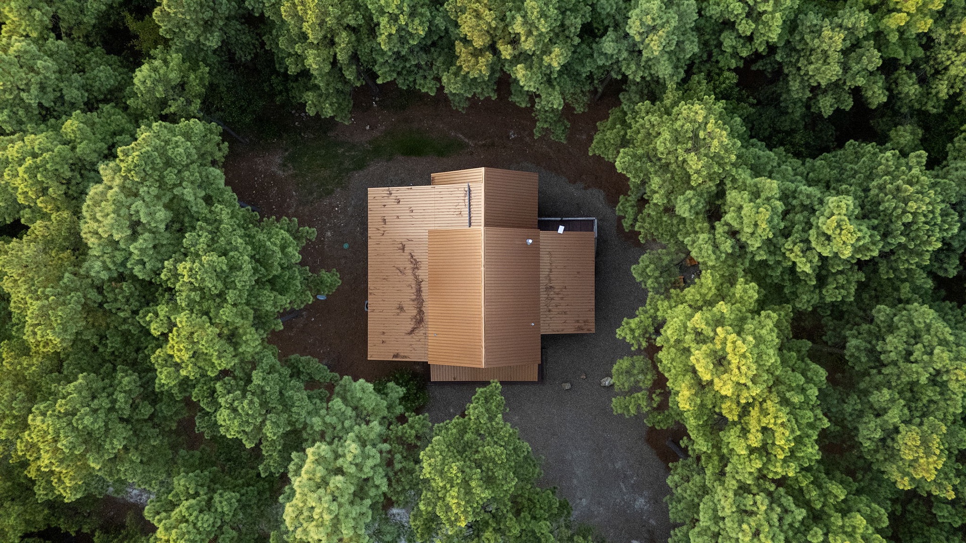Aerial view showcasing the property nestled within dense forest, offering complete privacy and a true escape surrounded by nature's tranquility.