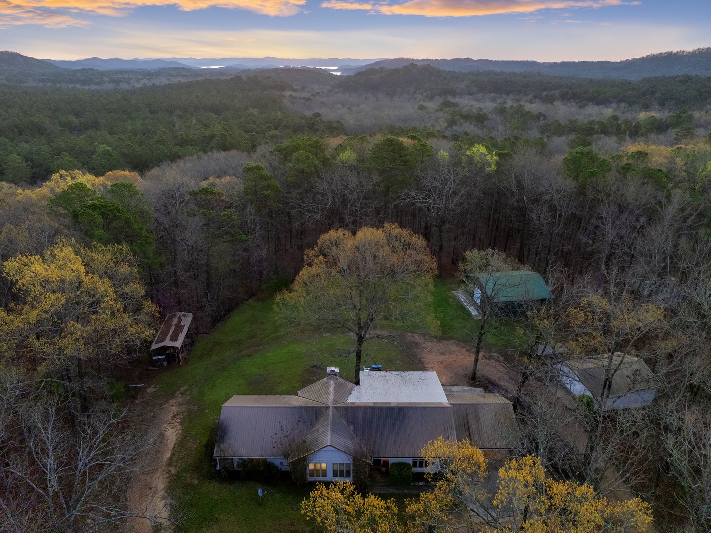 Secluded retreat nestled among rolling hills with distant mountain vistas and peaceful lake glimpses.