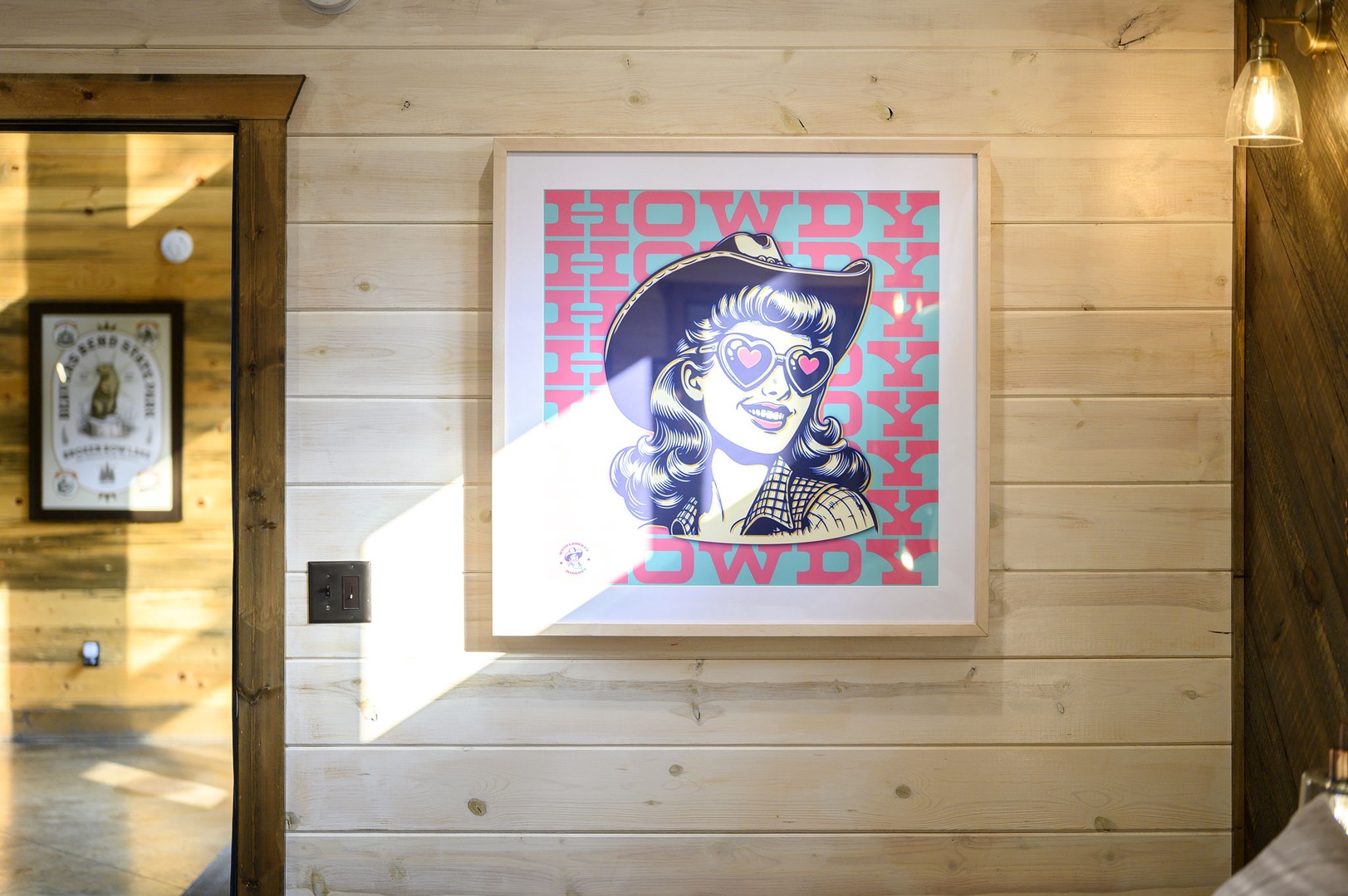 Cheerful western-style artwork adds character to this welcoming space. Natural wood paneling creates a warm, rustic ambiance perfect for your mountain retreat.