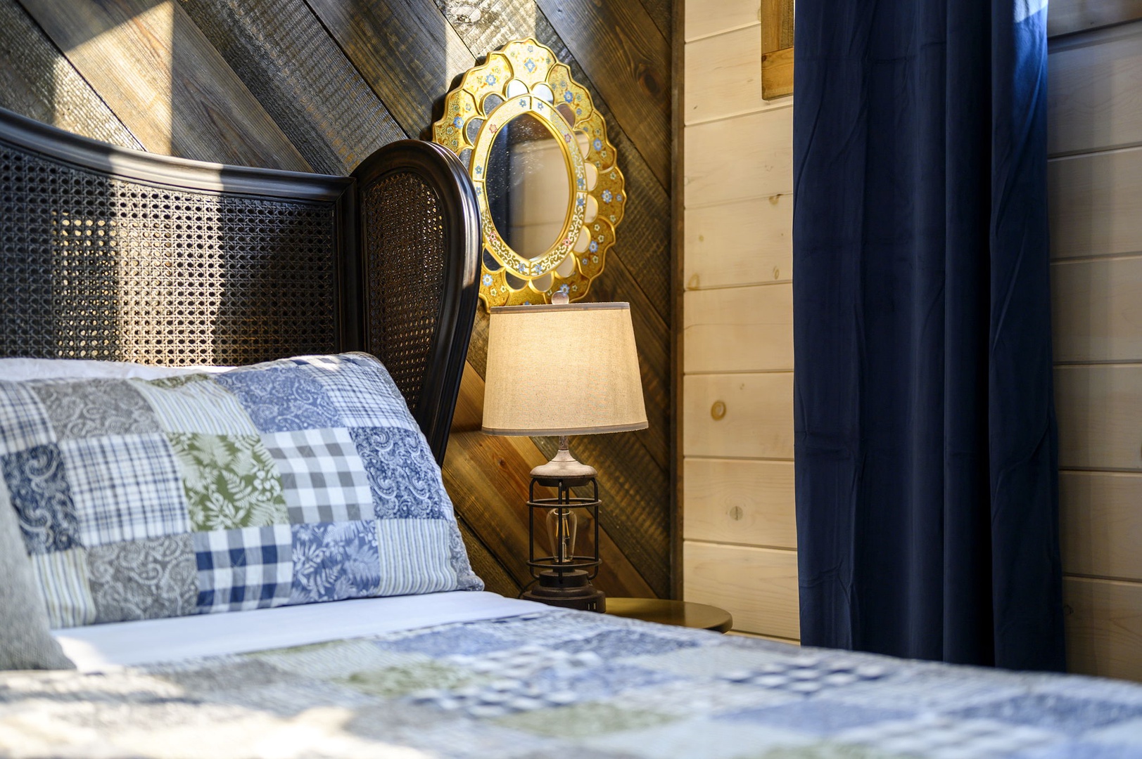Slip into your cozy retreat, where rustic shiplap meets charming details like the golden medallion mirror and soft bedside light. Wake feeling refreshed in this warmly styled haven.
