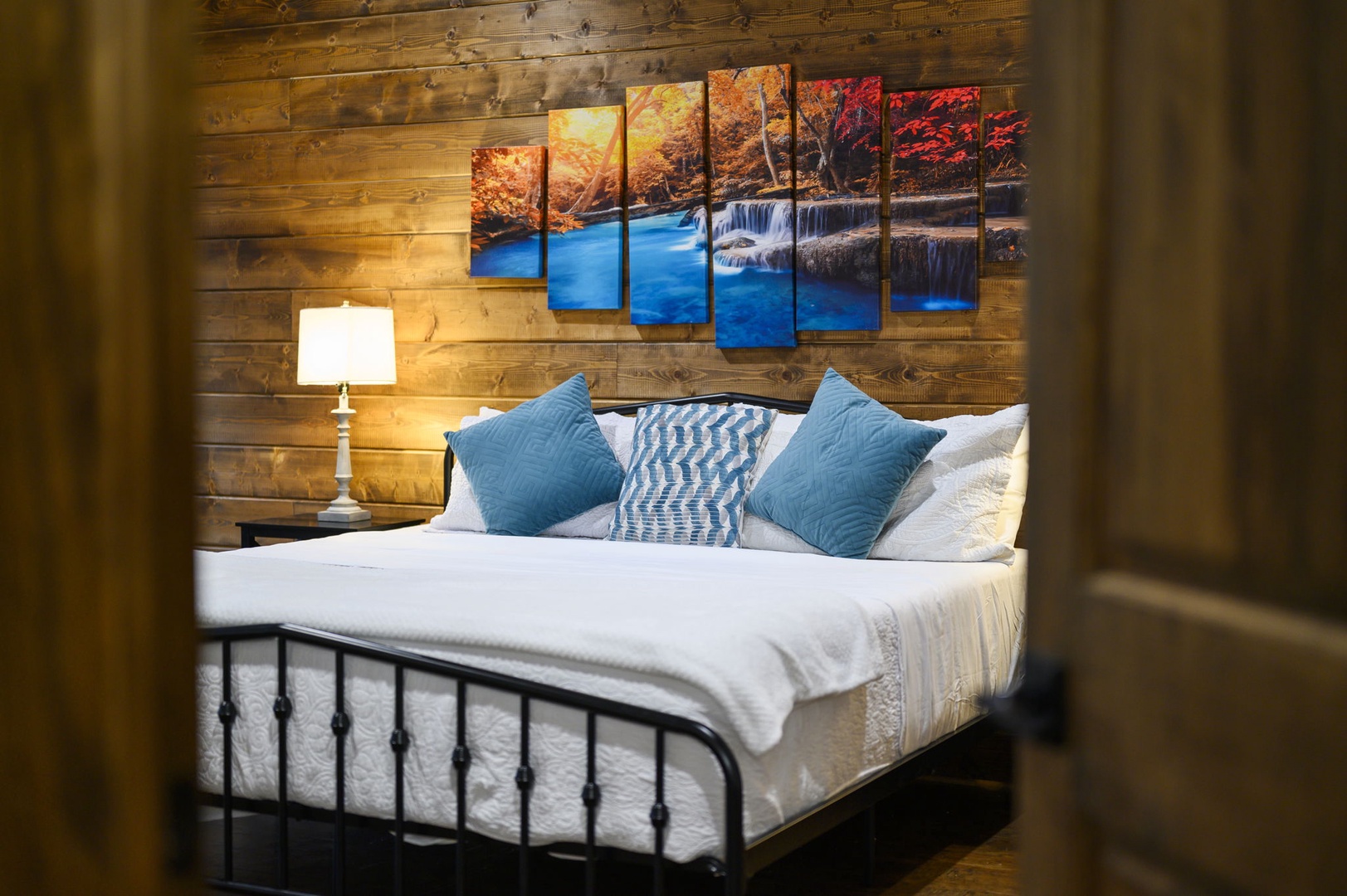 Sink into crisp white linens and let the warm wood walls surround you with rustic charm. This cozy bedroom invites you to unwind beneath soft lamplight after a day of adventure.