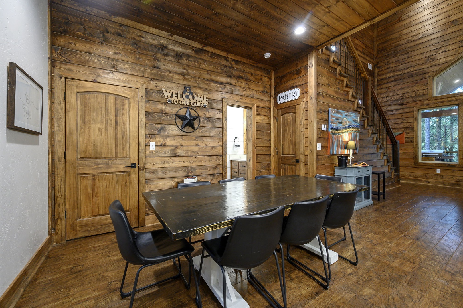 Step into your rustic cabin retreat where warm wood surrounds you and a welcoming dining space awaits your family gatherings under soaring vaulted ceilings.