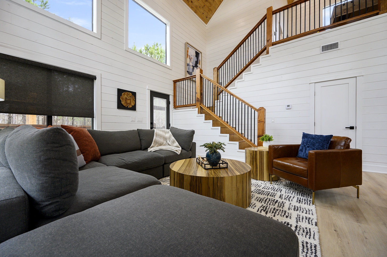 Sink into plush seating in your bright living room, where vaulted ceilings and natural light create an airy retreat perfect for relaxing.