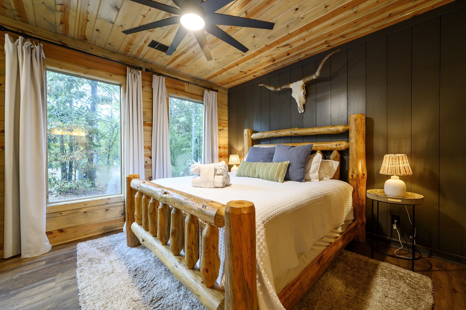 Drift off in your rustic log bed surrounded by warm wood tones and soft linens. Windows open to peaceful forest views, while the handcrafted details and cozy lighting make this your perfect mountain retreat.