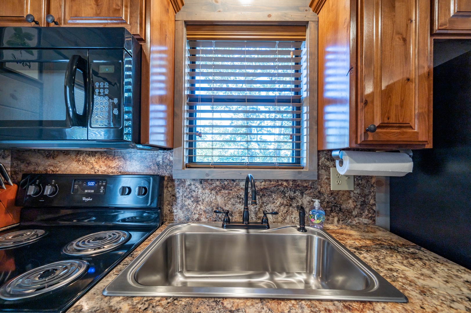 Your fully equipped kitchen features granite countertops, stainless steel appliances, and rich wooden cabinetry for preparing memorable meals.