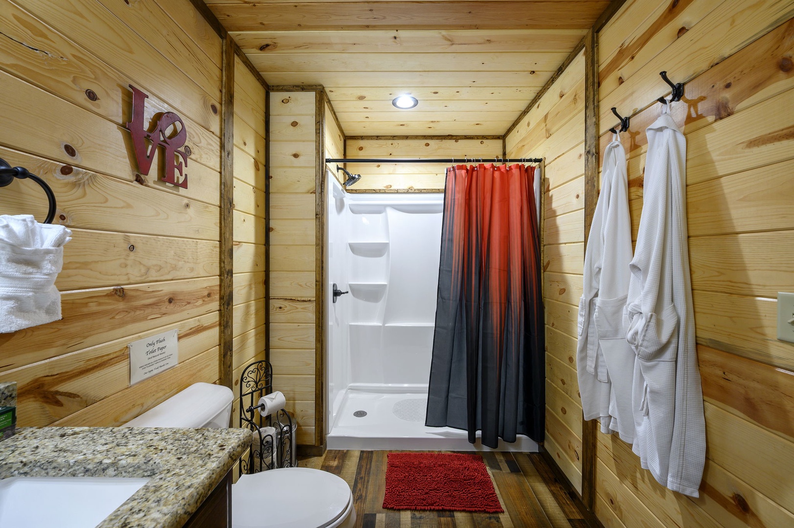 Step into your private retreat—a rustic bathroom where warm wood walls meet modern comfort, offering you a peaceful escape after a day of adventure.