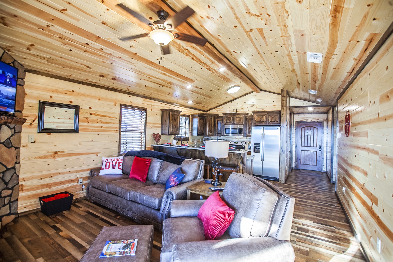 Sink into plush leather sofas surrounded by warm wood walls and beams. Your open-concept retreat features a fully equipped kitchen and cozy living space.
