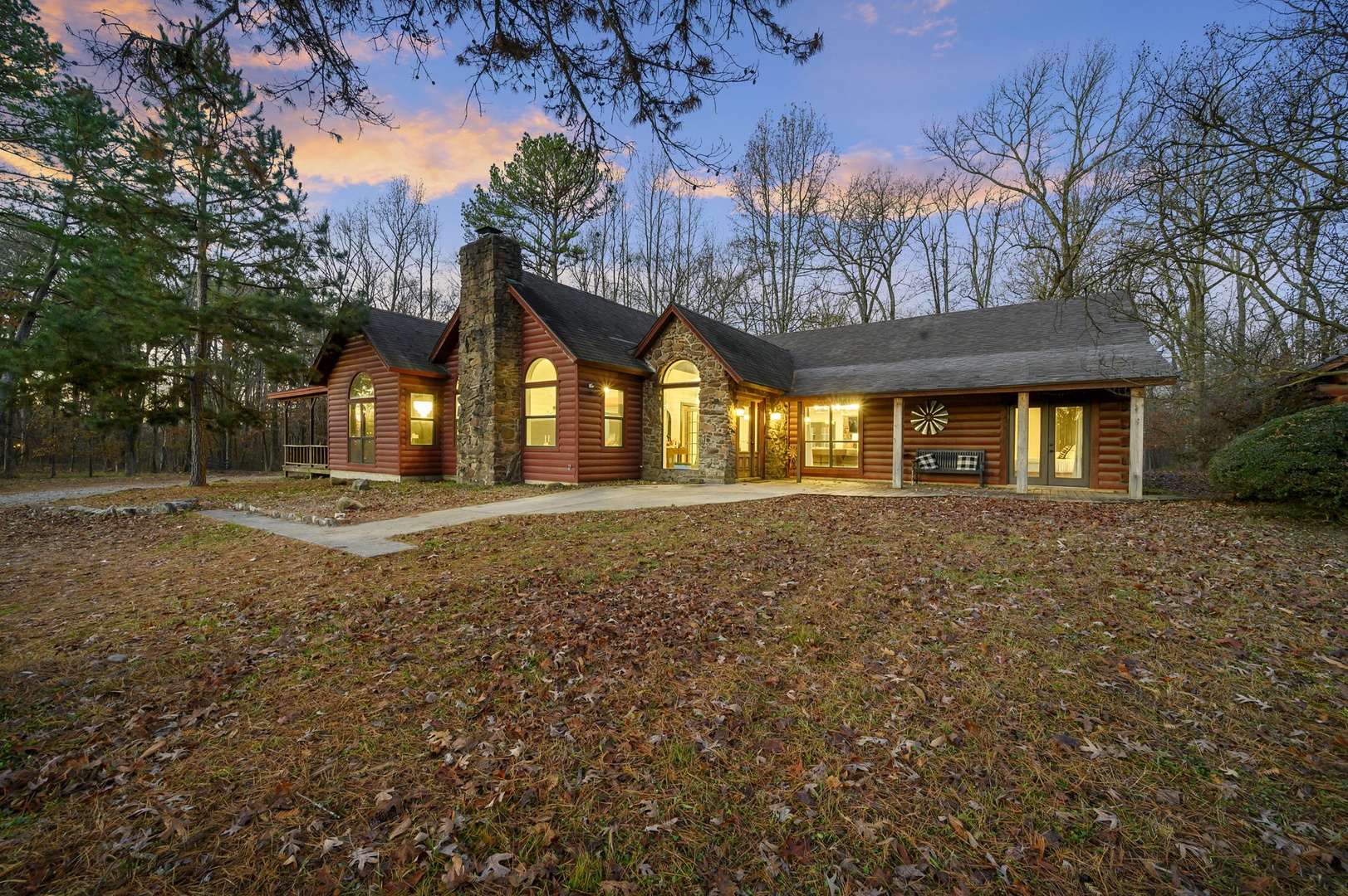 Rustic log cabin nestled among towering trees, offering a perfect woodland retreat with warm lighting welcoming guests at twilight.