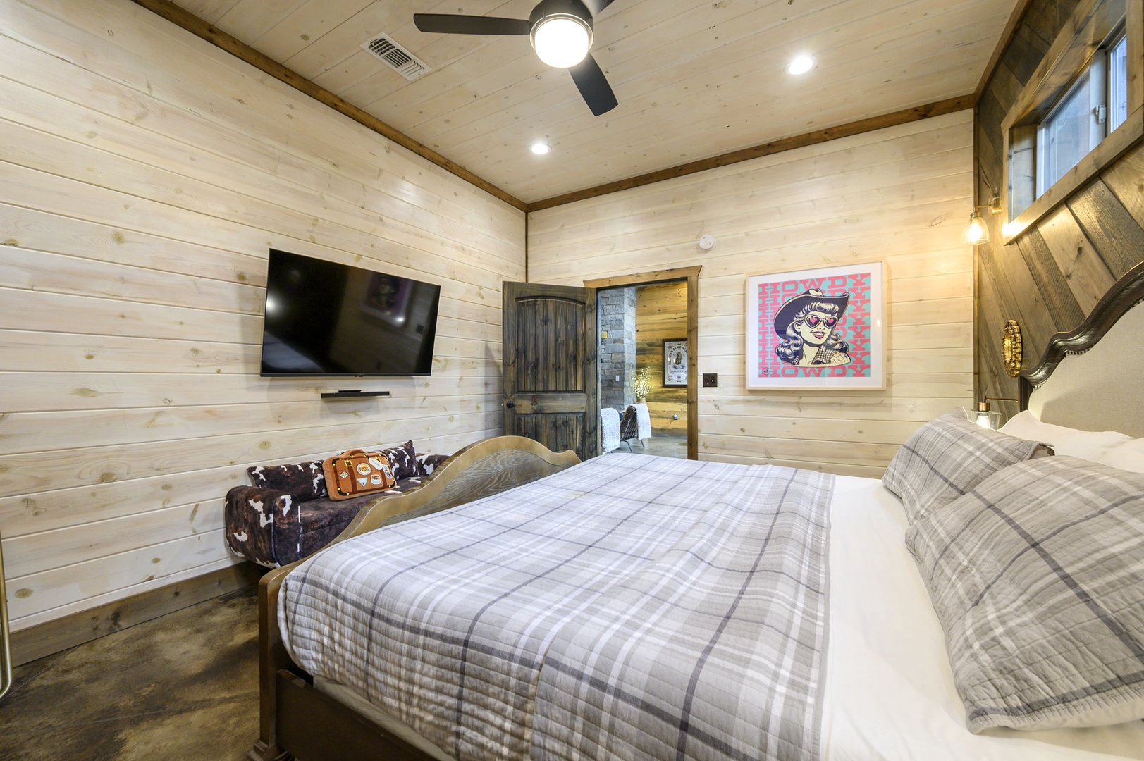 Slip into soft plaid linens in your cozy bedroom where rustic wood walls and thoughtful touches create a peaceful retreat for restful nights.