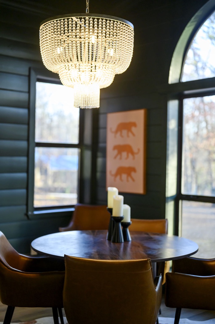 Gather around your elegant dining table beneath a stunning crystal chandelier, where intimate meals become memorable moments in this sophisticated space.