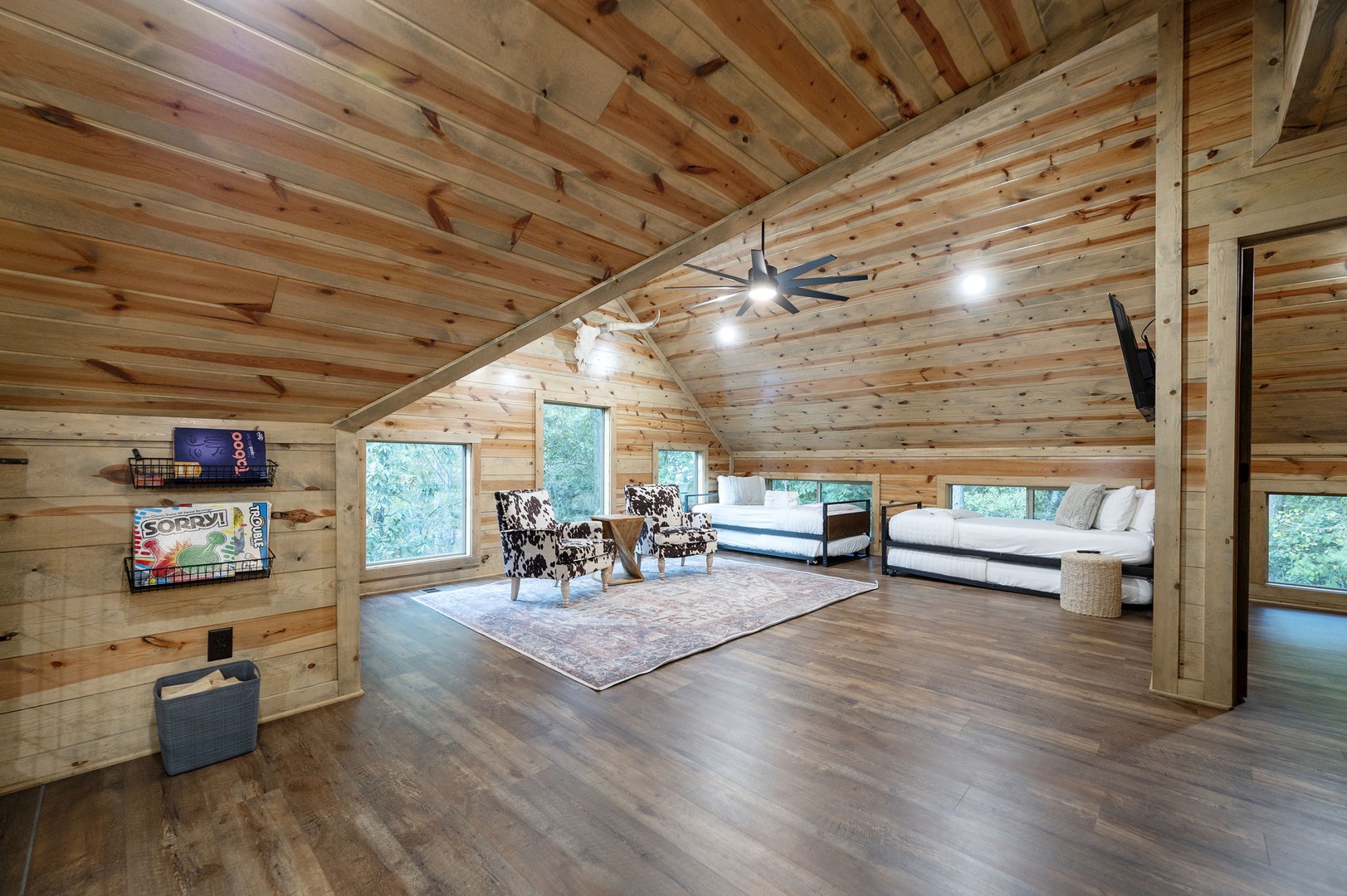 Retreat to your cozy loft bedroom with twin beds, vaulted wood ceilings, and peaceful garden views—a quiet haven perfect for reading or relaxing after a day of adventure.