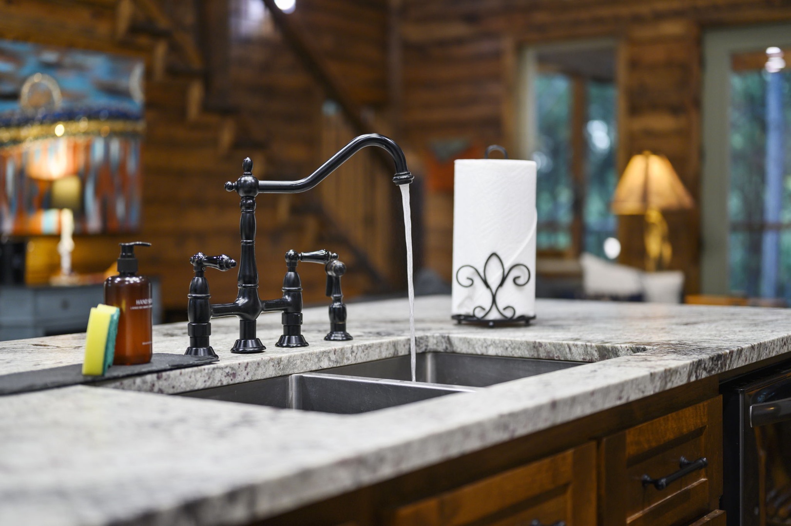Your rustic cabin's kitchen invites you to cook and gather with its elegant granite counters, classic bronze fixtures, and warm wooden charm.