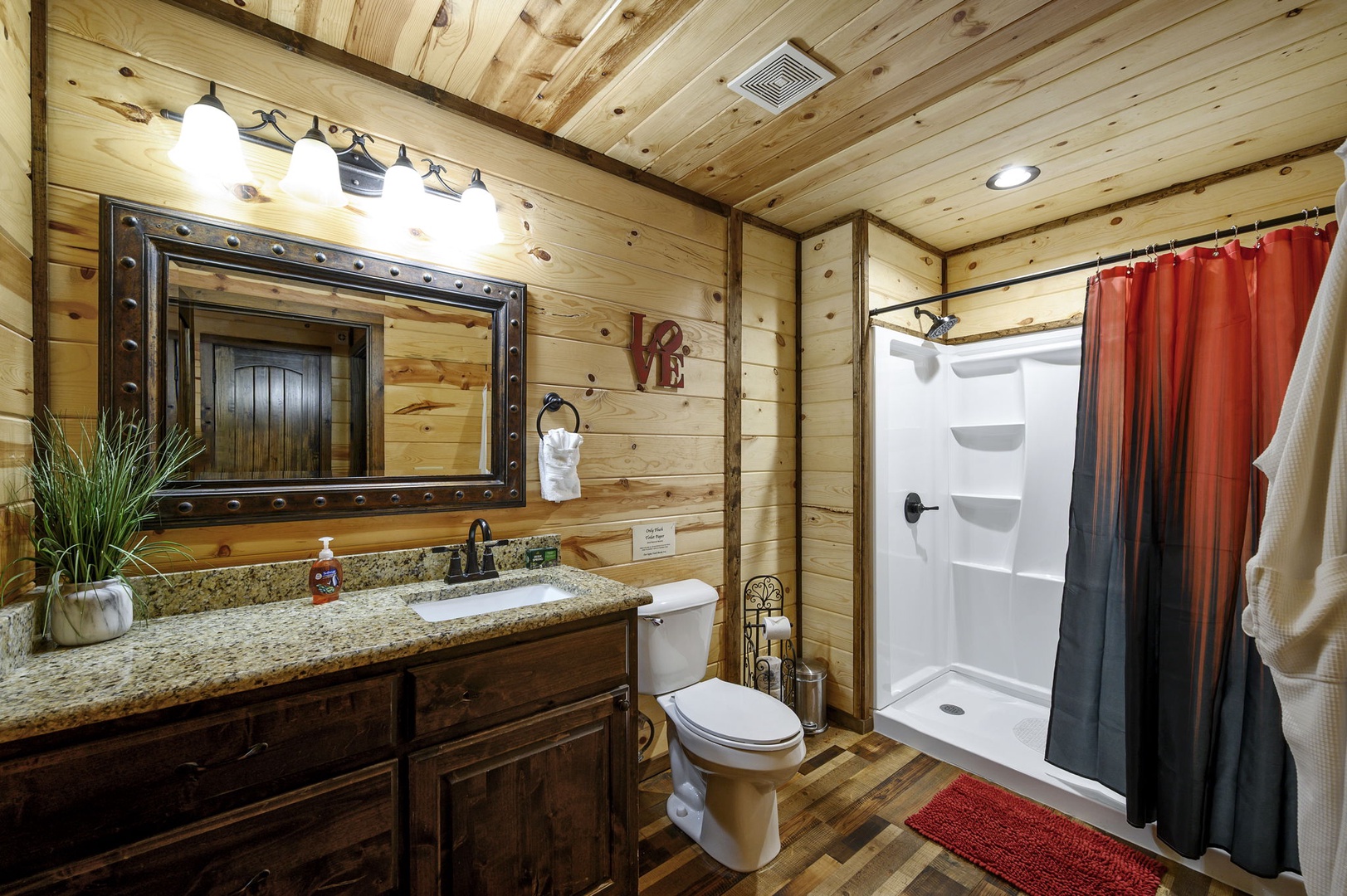 Step into your private retreat—a rustic bathroom where warm wood walls meet modern comfort, offering you a peaceful escape after a day of adventure.
