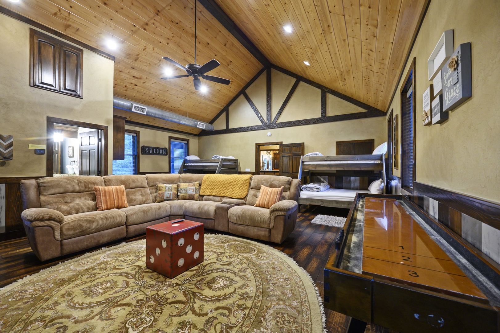 Relax on plush sofas under soaring wood-beam ceilings, then choose your bunk for the night—your cozy retreat combines spacious living with comfortable sleeping arrangements.