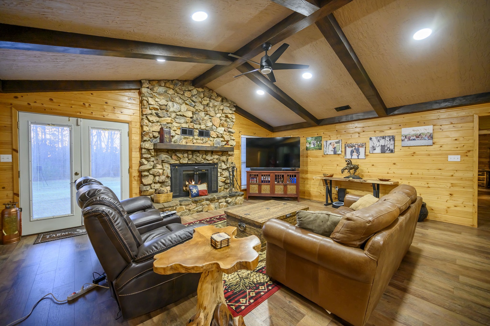Unwind in your cozy living room featuring rich leather seating, and rustic wood beams that create the perfect cabin atmosphere. Please note that the fireplace is not available for guest use.