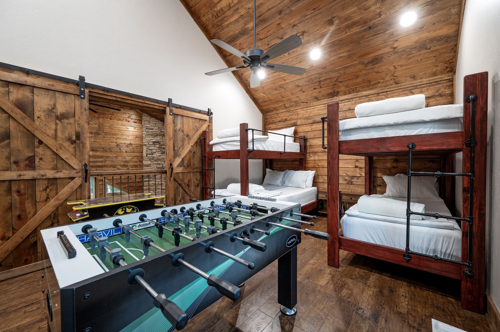 Challenge your group to a foosball match in this cozy bunk room with vaulted wood ceilings and rustic barn doors. Perfect for families or friends seeking both play and rest.