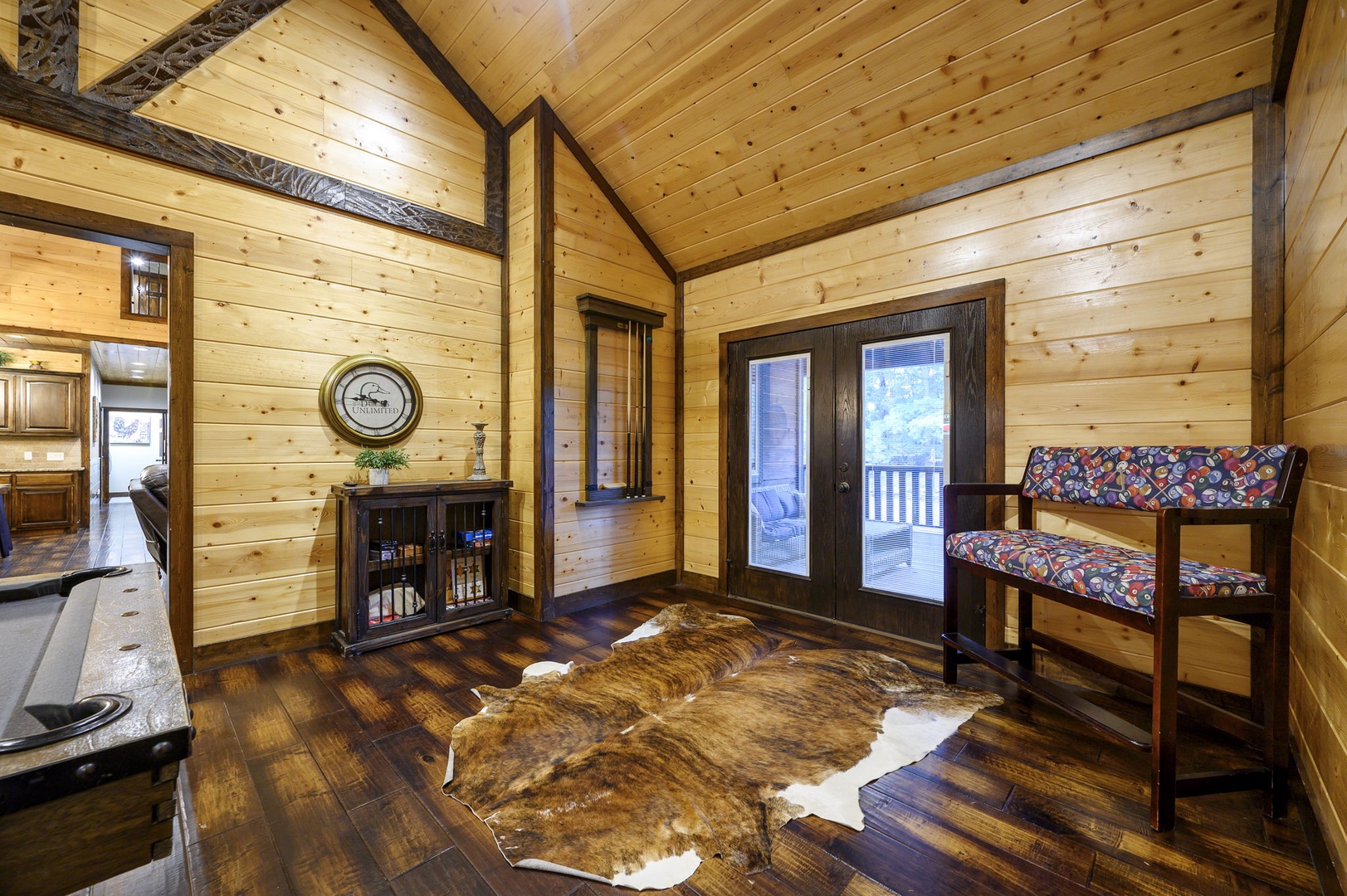 Step into your rustic mountain retreat with soaring vaulted ceilings, warm pine walls, and rich hardwood floors. The bunk bed and cozy cowhide rug add authentic cabin charm to your home away from home.