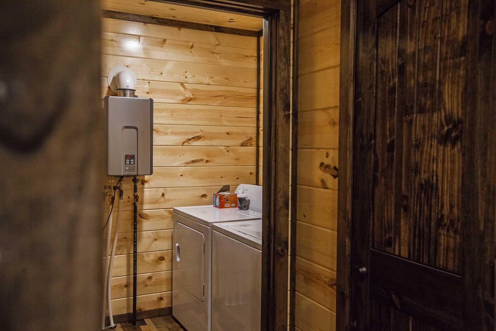 Your private laundry room features rustic wood paneling and modern appliances for convenient washing and drying.
