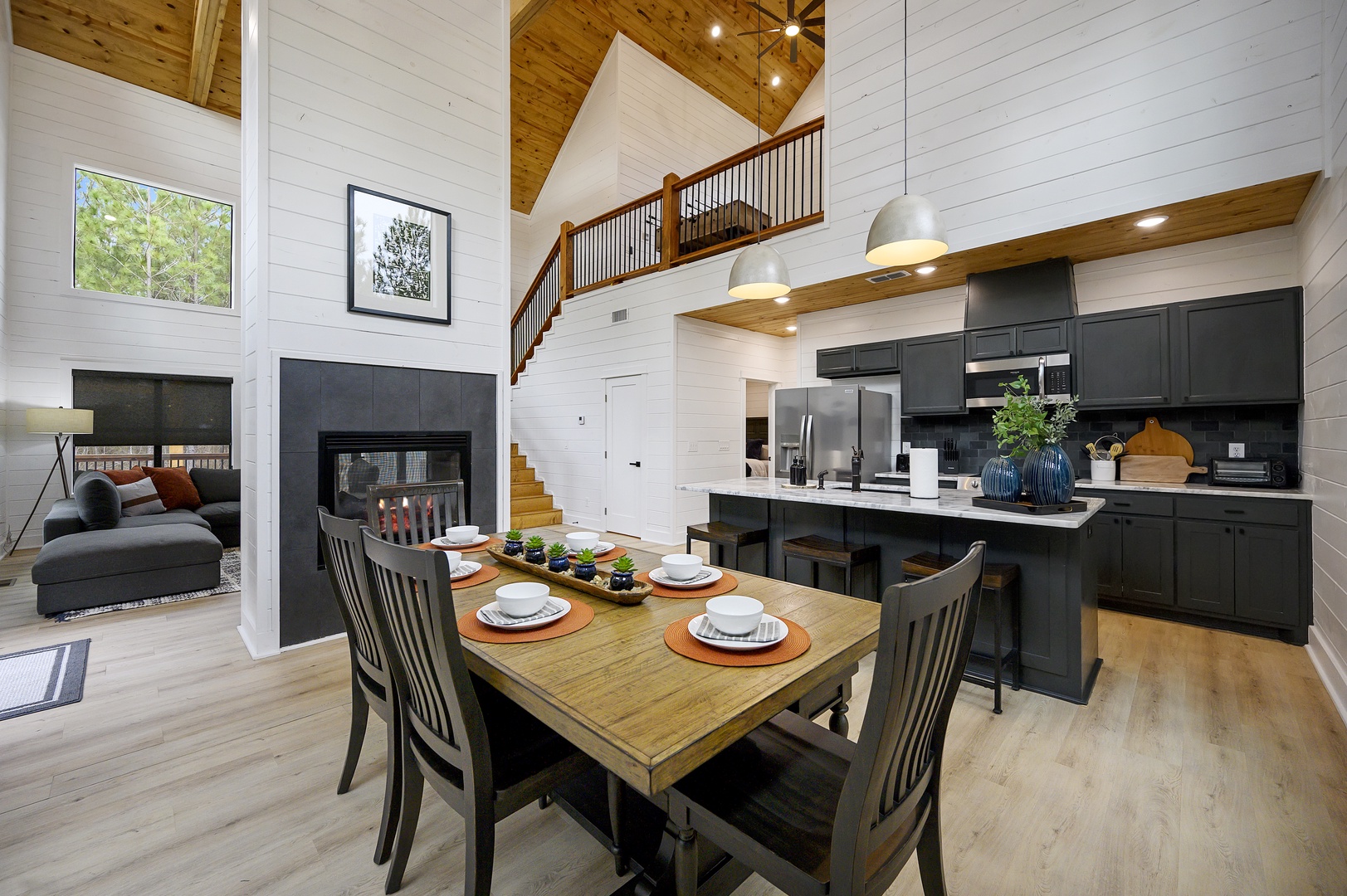 Open-concept living blends farmhouse charm with modern luxury—your soaring ceilings, cozy fireplace, and gourmet kitchen await memorable evenings together.