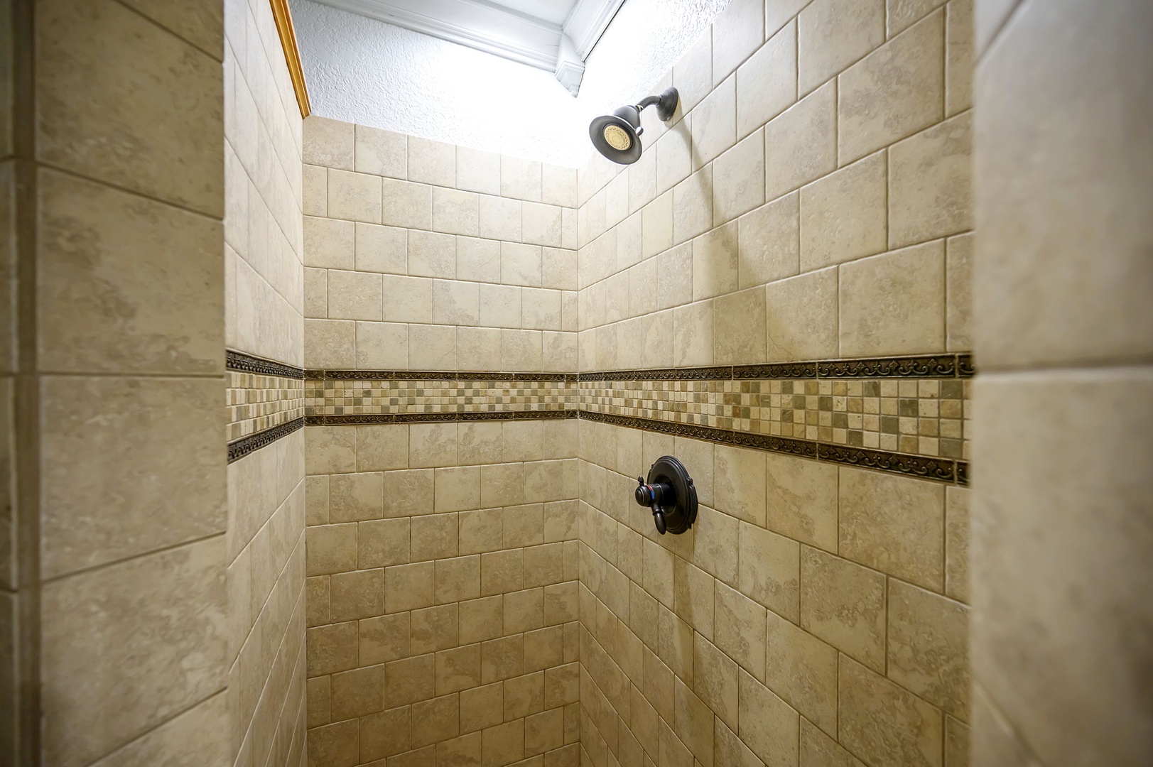 Step into your luxurious tiled shower with natural light streaming through the skylight above.