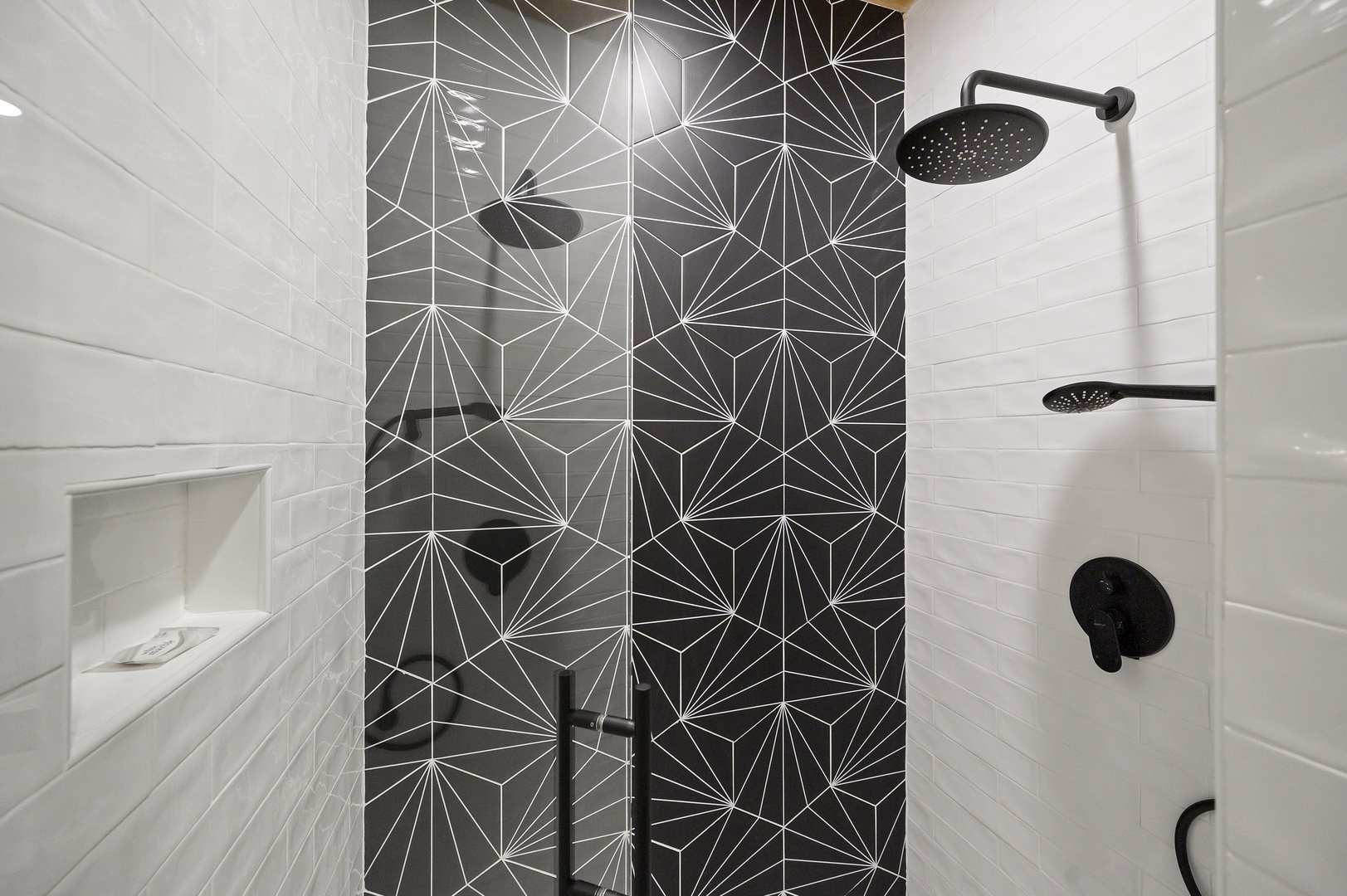 Step into your sleek shower featuring stunning geometric tiles and modern rainfall showerhead for a refreshing start to your day.