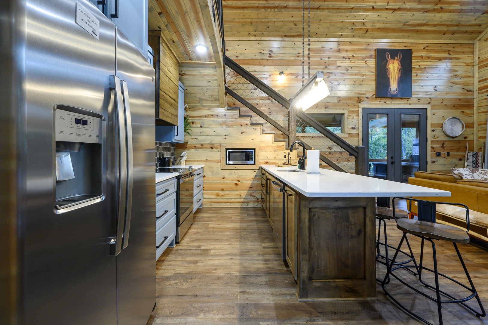 Picture yourself preparing meals in this modern kitchen, where rustic wood meets sleek stainless appliances. Sunlight streams through French doors while you gather around the spacious island, creating memories in your home away from home.