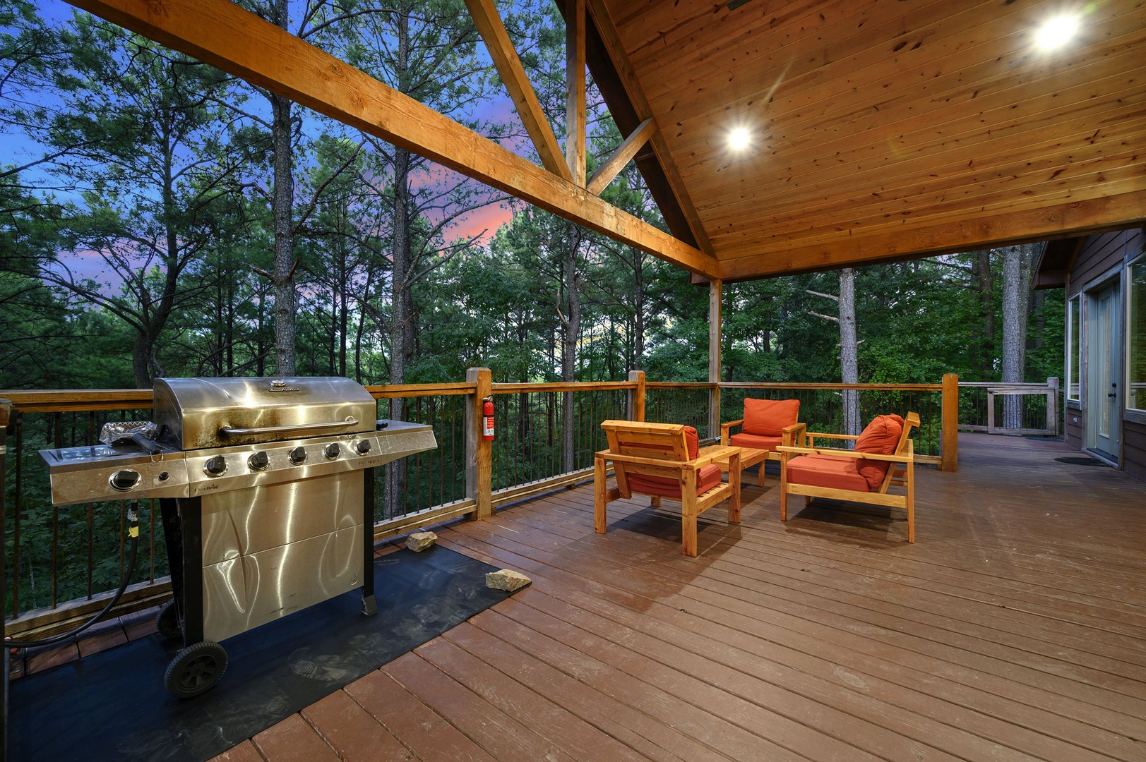 Unwind on your private covered deck, where the scent of pine mixes with the sizzle of the grill. Sink into plush seating and watch the sky shift through the trees—your perfect evening retreat.