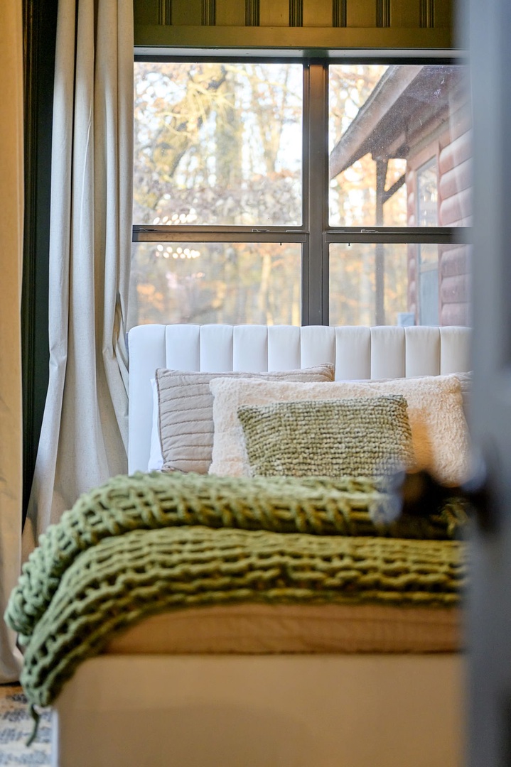 Sink into your cozy window seat with soft textures and natural light filtering through autumn views.