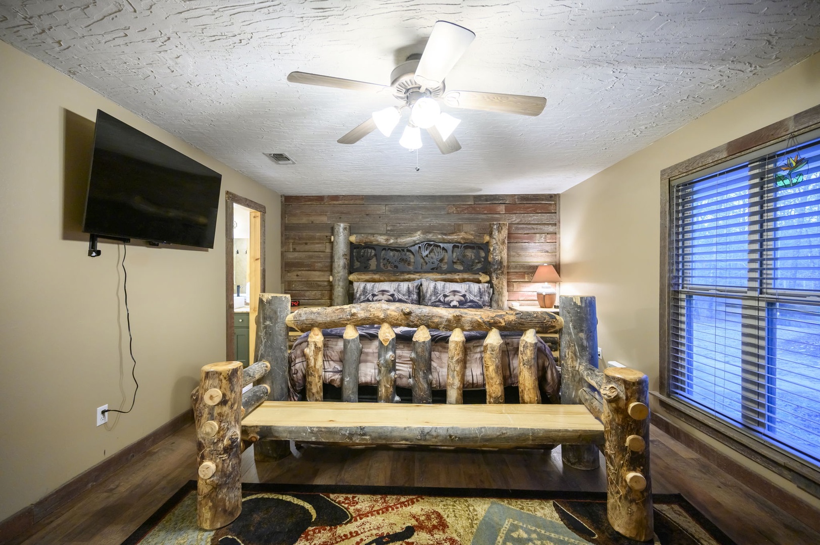 Rest easy in your rustic log bed with handcrafted wooden details, complete with TV and peaceful forest views.