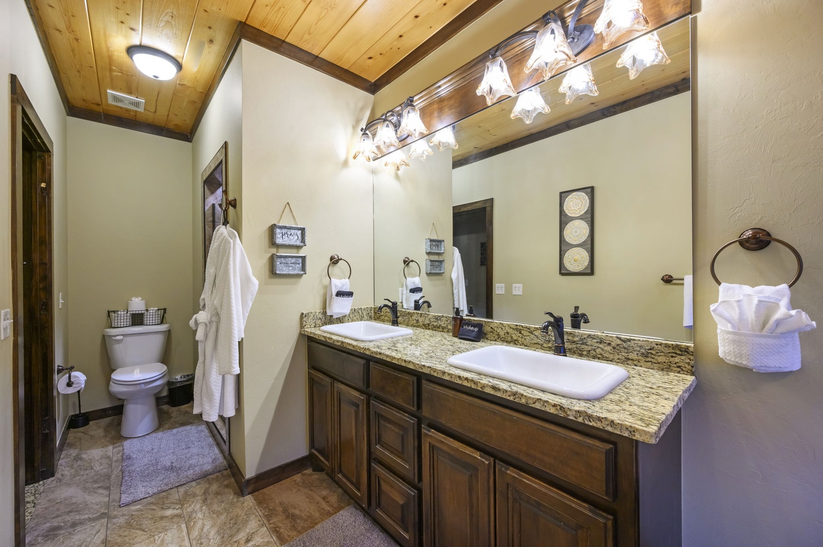 Step into your private bathroom where rustic wood-beam ceilings meet modern comfort. Fresh towels await, and the spacious vanity gives you plenty of room to settle in and unwind.