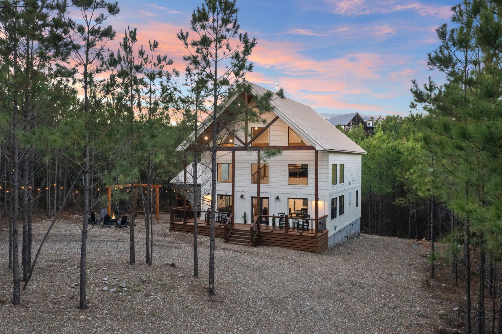 Tucked among towering pines, this beautiful home offers a spacious deck with outdoor seating, swings for stargazing, and a cozy firepit for evening gatherings.