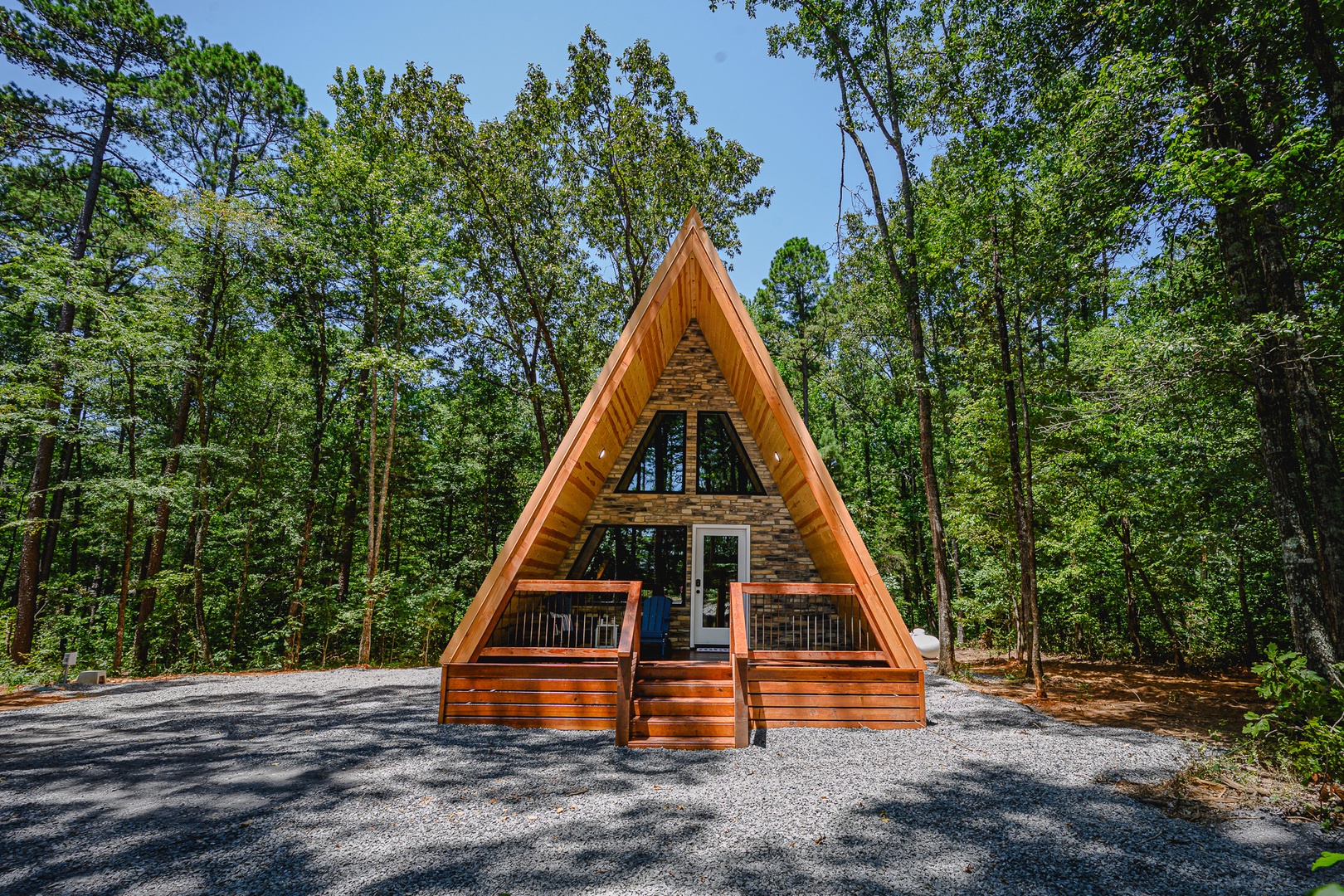 A charming A-frame cabin nestled in a peaceful wooded setting, surrounded by towering trees and natural beauty—the perfect secluded retreat for your escape.