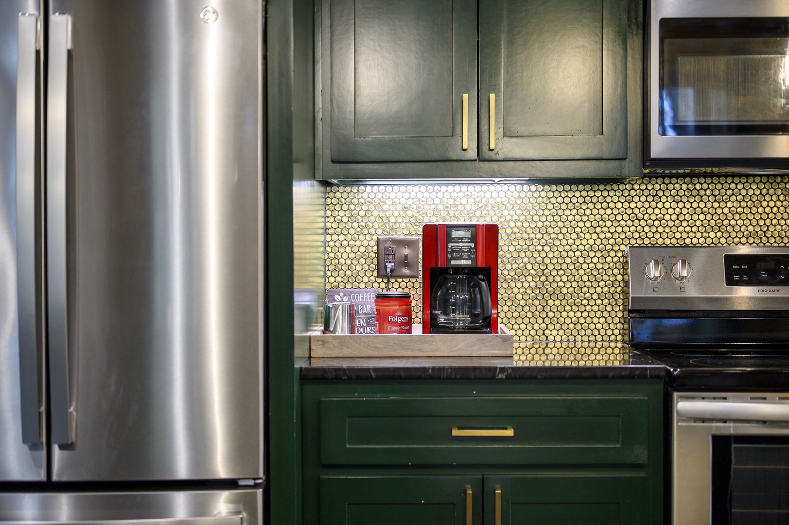 Your kitchen awaits with rich green cabinetry, gleaming stainless appliances, and a charming penny-tile backsplash. Brew your morning coffee at the dedicated coffee station and feel right at home.