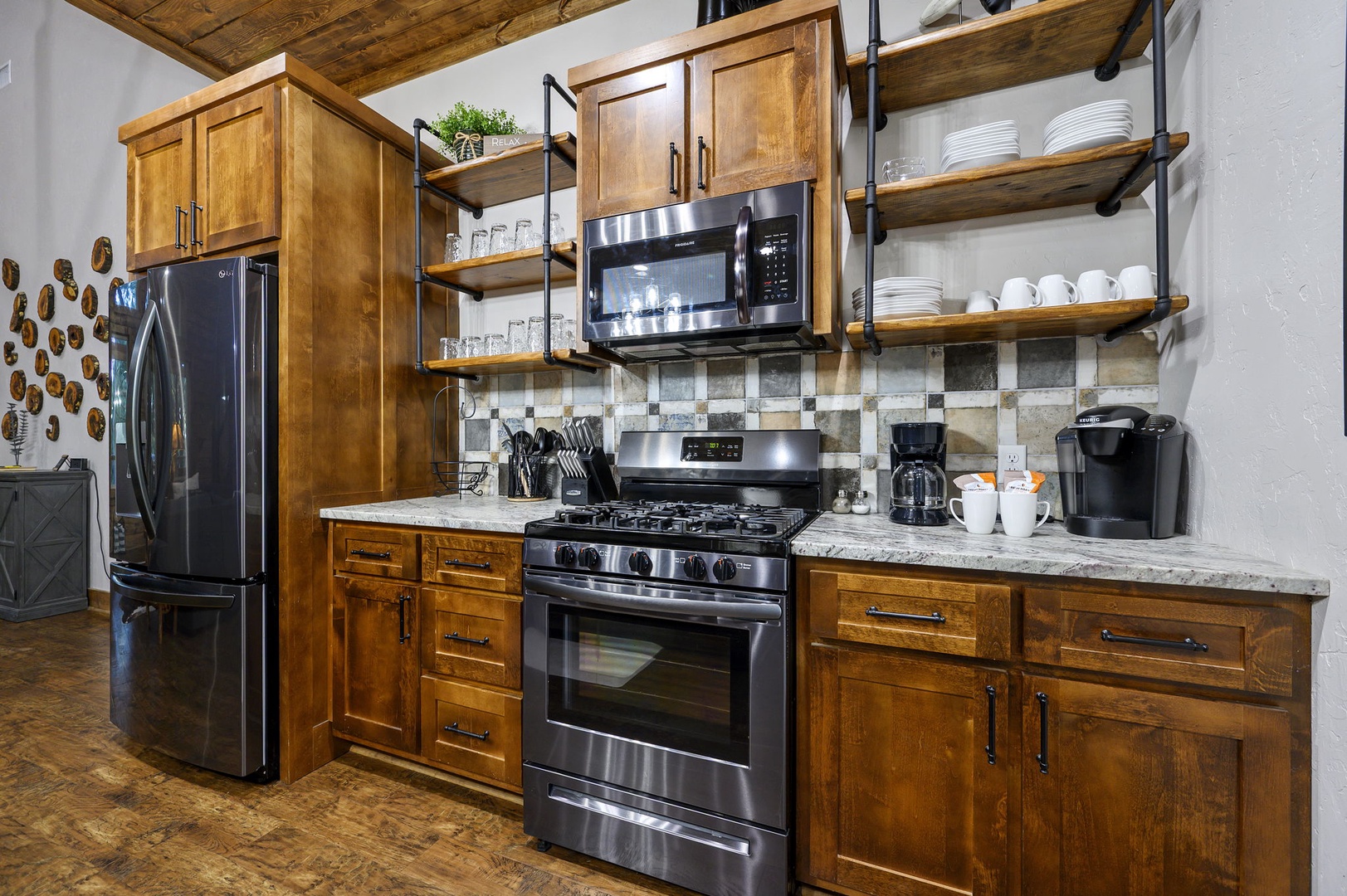 Your fully equipped kitchen blends rustic warmth with modern convenience—cook meals in this inviting space with stainless appliances, ample counter space, and charming wood accents overhead.