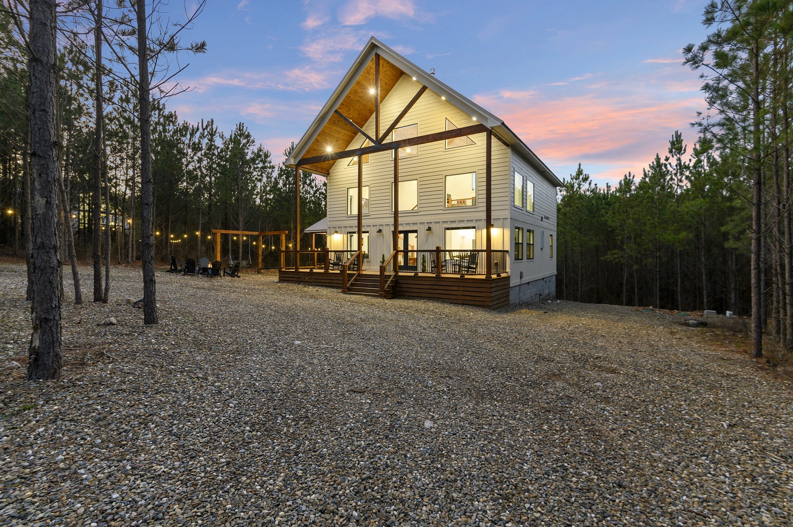 Modern cabin nestled in peaceful pine forest with stunning architectural design and warm evening lighting.