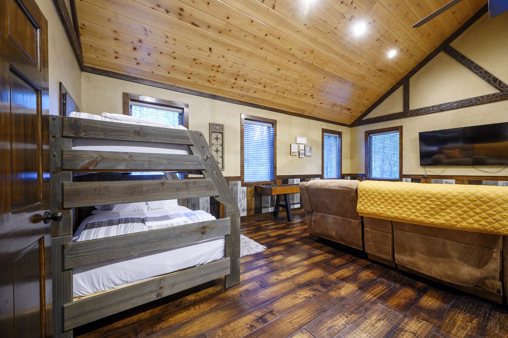 Gather together in this inviting space with rustic wood beams, cozy bunk beds, and a plush armchair—perfect for families or groups looking to unwind after a day of adventure.