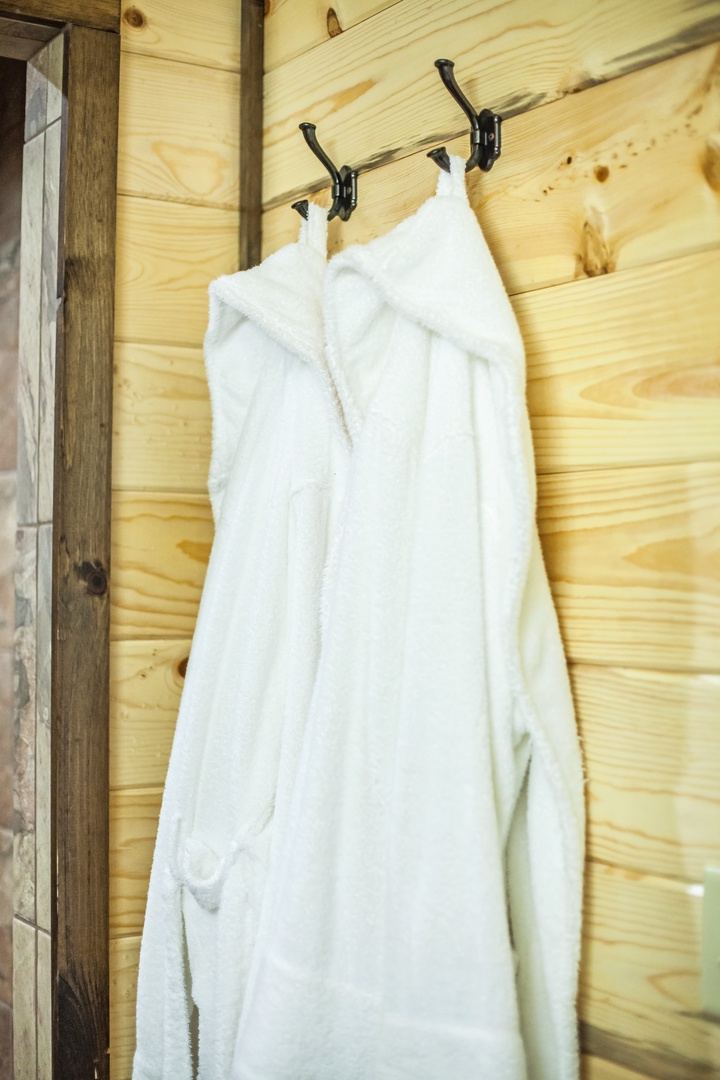 Wrap yourself in the plush comfort of your private bathrobes, hanging ready in your cozy wooden retreat.