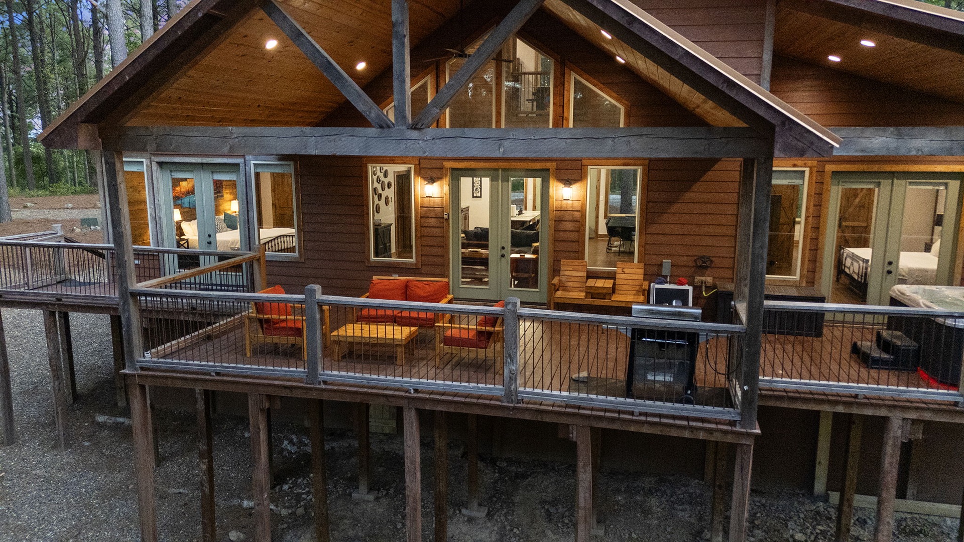 Nestled among towering pines, this inviting retreat showcases expansive glass doors opening to a spacious deck where you'll enjoy outdoor dining and forest tranquility.