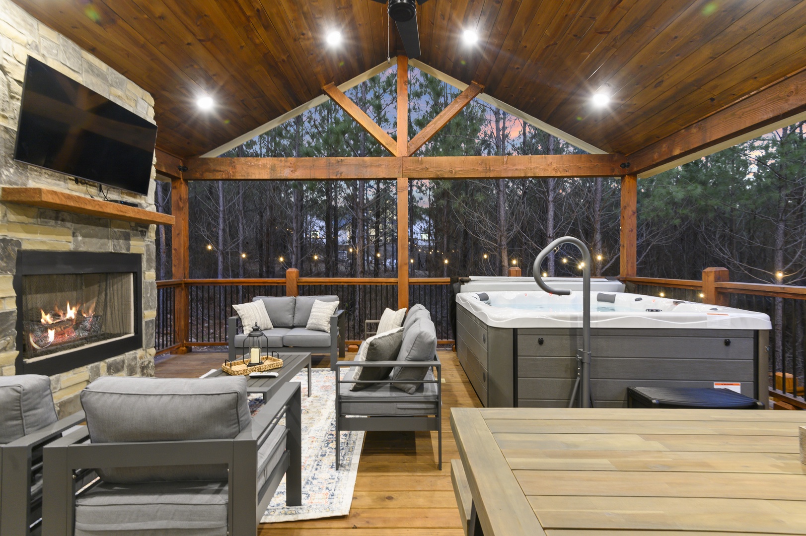 Unwind in your private covered deck with crackling fireplace, plush seating, and hot tub overlooking peaceful woods.