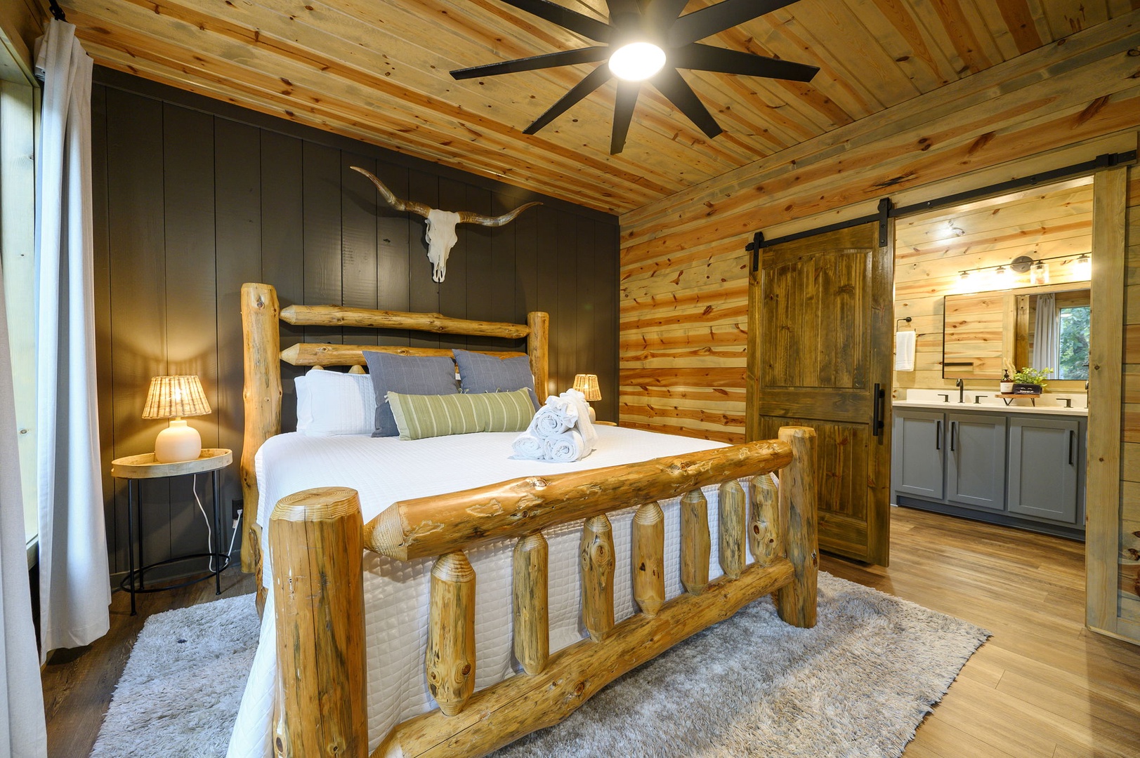 Relax in your private rustic retreat, where handcrafted log furniture and warm wood tones create a cozy, inviting atmosphere. Soft lighting and modern touches bring comfort to this charming cabin-style bedroom.
