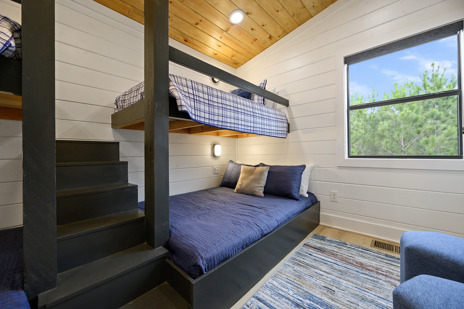 Sleep peacefully in your cozy bunk beds with soft linens and warm lighting, while enjoying tree views through your private window.